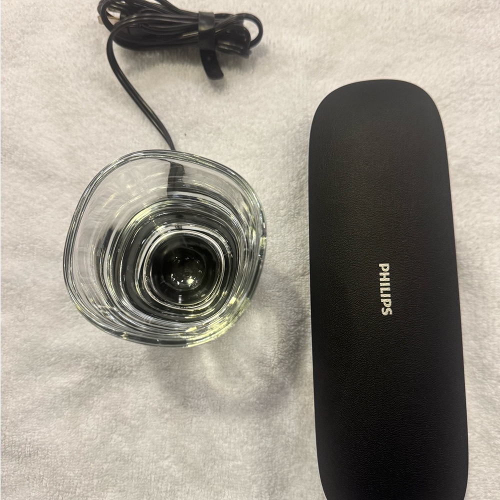 Philips Black Electric Toothbrush, Glass, charger and charging case.